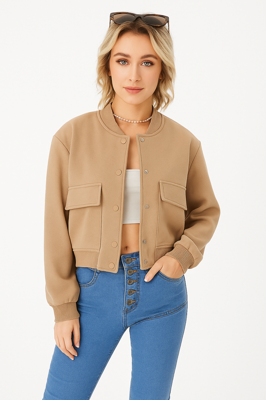 Women’s lightweight cropped bomber jacket in beige with snap buttons and flap pockets, styled with high-waisted jeans and sunglasses.