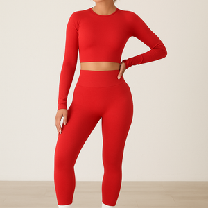 Woman wearing a red fitted long-sleeve crop top and high-waisted leggings fashion exercise yoga suit with white sneakers.